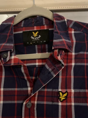 Röd Lyle&scott skjorta  - Säljer en riktigt snygg röd rutig lyle & scott skjorta i fint skick. Storlek S med normal passform. Sparsamt använd. 