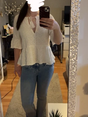 Vit blus med volang och knyt - Använd några gånger men inga defekter som syns!