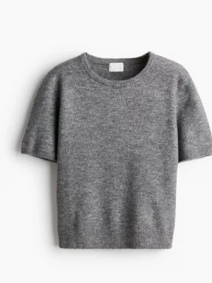 Grå stickad topp med kort ärm - Mysig grå stickad topp med rund halsringning och korta ärmar. Perfekt till både jeans och kjol för en enkel men snygg look. Ribbad kant nedtill och vid ärmslut ger en extra detalj.