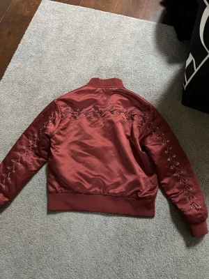 Vinröd bomberjacka med snörning - Snygg vinröd bomberjacka från forever 21 med cool snörningsdetalj längs ärmar och rygg! 🤍🌷