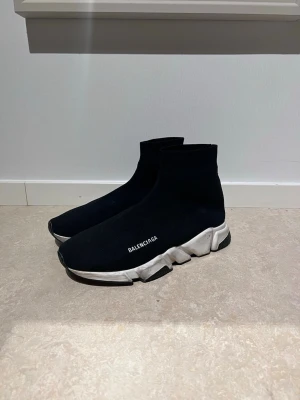  Speed Trainer svarta sneakers - Svarta Speed Trainer sneakers med vit chunky sula och stickad ovandel i textil. Strumpliknande passform och diskret logga på sidan. Perfekta för en modern och sportig look. 