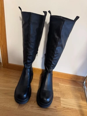 Truffle Collection Stövlar  - Snygga svarta knähöga stövlar med chunky sula och dragkedja på insidan. Perfekta för en trendig och edgy look.