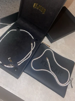 Kejser glittrande tennis halsband - Säljer ett snyggt tennis halsband från Kejser med gnistrande stenar i silverfärg. Halsbandet har en klassisk, elegant design och kommer i originalförpackning samt med en svart Kejser-pouch. Perfekt för dig som gillar bling och vill sticka ut. 2st för 1599kr