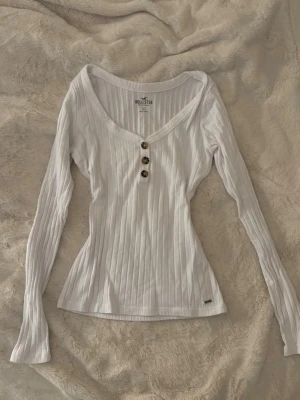 vintage hollister topp ribbad  - super söt vit tajt figurnära långärmad ribbad topp från hollister med djup urringning och knappar. jätte fint skick! stl S 💕