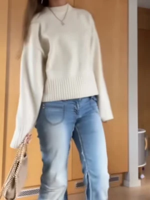 Vit stickad tröja med vida ärmar - Säljer en stilren vit stickad tröja med bred ribbstickad kant nedtill och vid ärmslut. Tröjan har en rak passform och rund halsringning. Perfekt för dig som gillar en enkel men trendig look.