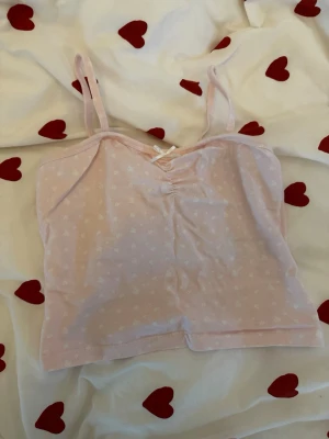 Rosa linne  - Rosa linne från Ginatricot med vita blommor på och en rosett. Använd typ 2 gånger, inga defekter. Strl 158-164 vilket motsvarar typ en S