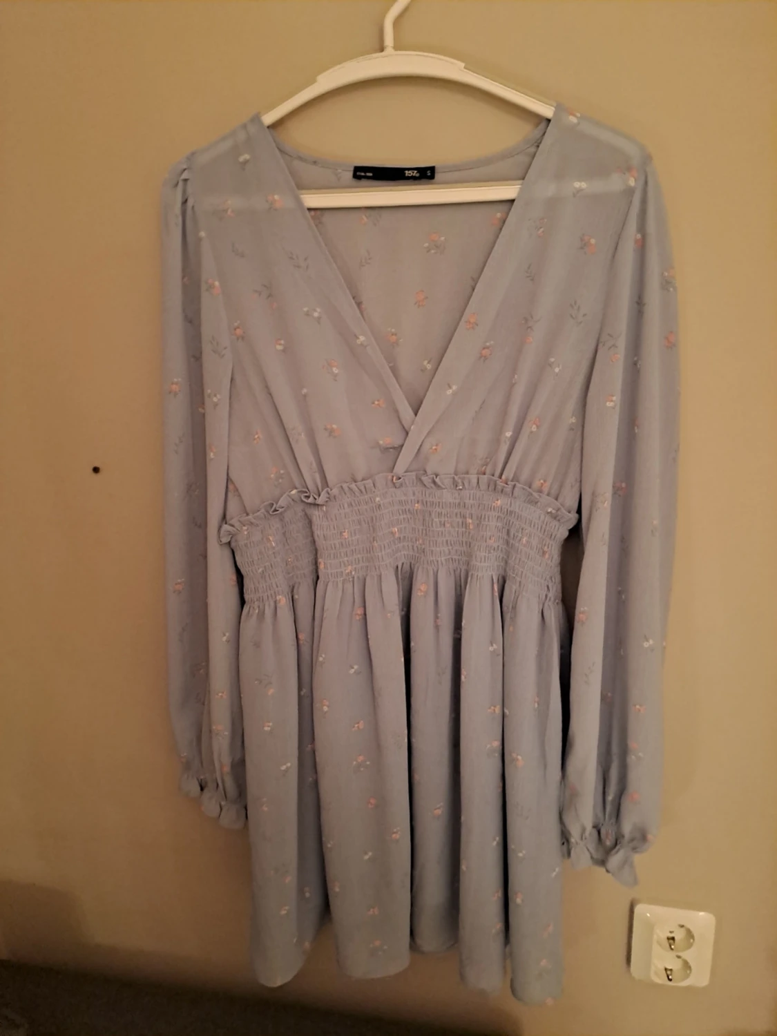 Ljusblå blommig omlottklänning