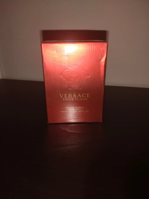 Versace Eros Flame EdP 100ml - Versace Eros Flame Eau de Parfum 100ml kommer i en lyxig röd och guld kartong med Medusa-huvudet i relief. Doften är intensiv och elegant, perfekt för dig som gillar exklusiva parfymer med karaktär. Flaskan är av glas och förpackningen har en modern, stilren design.