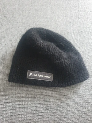 Svart mössa från Peak Performance - Säljer en svart stickad mössa från Peak Performance med diskret logga framtill. Modellen heter HANNESEAN och mössan är tillverkad i mjukt material som passar perfekt för kyliga dagar. Enkel och stilren design som funkar till det mesta.