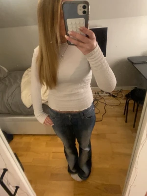 Vit festtopp - Säljer en vit långärmad topp med coolt material. Stretchig struktur. Perfekt att styla med jeans. Cool att ha på fest💞