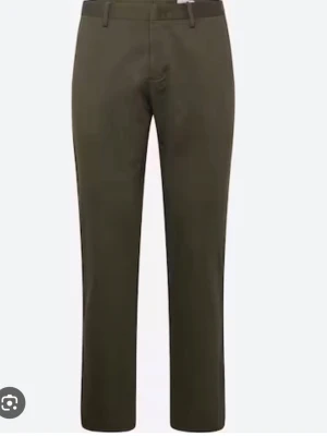 Mörkgröna chinos från NN07 modell Theo 1420 - Snygga mörkgröna chinos från NN07 i rak modell. Byxorna har klassiska bälteshällor och är tillverkade i ett mjukt bomullsmaterial med lite stretch för extra komfort. Nypris 1599, knappt använda.