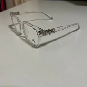 Chrome Hearts Blue-Light Glasses - ✨ Chrome Hearts Blue-Light Glasses✨ 👓 Frame: Clean see through acetate with iconic Chrome Hearts silver-tone details 🎨 Color: Black with Silver details 🔵 Lenses: Blue-light blocking (non-prescription) 📌 Condition: Excellent – barely worn, like new 💎 Details: Signature CH cross motifs on temples + engraved arms 🧼 Fully cleaned & hygienic 🔥 Perfect for screen time, studying, office work, or daily wear 💼 Lightweight & comfortable fit 🚀 Fast shipping guaranteed 