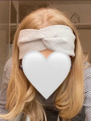 Ljusgrå ribbad twistad hårband Dilling - Supersnyggt ljusgrått hårband i ribbat tyg med twistad detalj framtill. För utomhusbruk från märket Dilling. Mjuk och stretchig för skön passform. Endast provat, aldrig använt. NOTERA jag har 52 cm i omkrets runt huvudet och det passar mig perfekt.