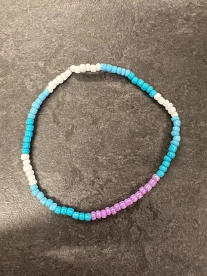Färgglatt pärlarmband i blått och lila storlek XL - Ett handgjort armband med pärlor i blått, vitt och lila. 