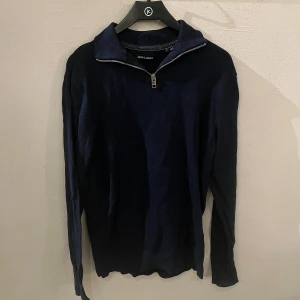 Halv zip kofta - Snygg marinblå långärmad tröja från Jack & Jones med half zip-dragkedja i halsen. Tröjan har en klassisk passform och är gjord i mjuk bomull, perfekt för dig som gillar stilrena och enkla plagg. Passar till jeans eller chinos. Nypris cirka 700