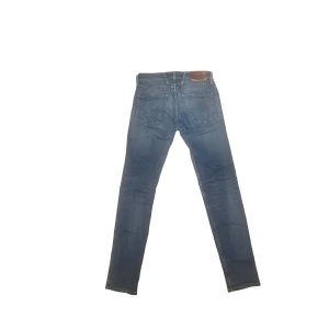 Replay Anbass blå jeans slim fit W28 - Snygga blå slim fit jeans från Replay i modell anbass i storlek W28 L32. Jeansen har coola slitningar på fickor med mera, bruna läderpatch bak och signaturbroderi på bakfickan. Perfekt passform och stilren look. Finns ett väldigt litet hål nära gylfen (se bild) som inte är synligt om man inte tittar noga! Platta mått: Midja: 37cm Ytterlängd: 103cm Benöppningen: 15cm