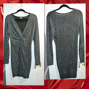 Glittrig svart-silver kortklänning H&M - Snygg glittrig silverfärgad kortklänning från H&M med lång ärm och djup v-ringning. Klänningen har twistad detalj framtill som ger en cool effekt. Perfekt för dig som vill sticka ut med en festlig look. Materialet är stretchigt och följsamt.
