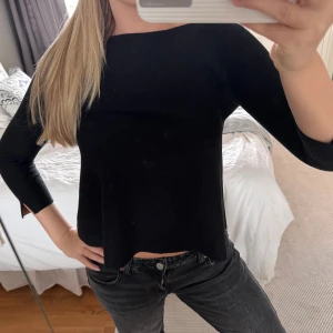 Svart långärmad topp från COS - Minimalistisk svart långärmad topp från COS i storlek S. Toppen har en rak, något croppad passform och är tillverkad i ett mjukt material med stretch. Perfekt till jeans eller kjol för en clean look.