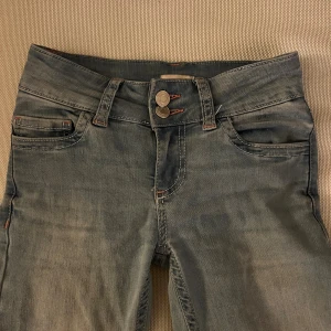 Lågmidjade jeans från nelly - Ljusa lågmidjade jeans från nelly med rosa detaljer på fickorna. I storlek 32 men de är uppsydda så skulle säga att de passar någon som är runt 155cm. Pris kan diskuteras🥰