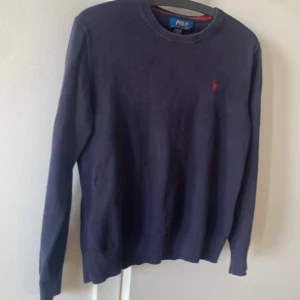 Mörkblå tröja från Polo Ralph Lauren - Priset är såklart förhandlingsbart. Men lite info om tröjan! Snygg mörkblå tröja från Polo Ralph Lauren med klassisk rund hals och diskret röd logobrodyr på bröstet. Tröjan är långärmad och har ribbade muddar vid ärmslut och nederkant. Perfekt för dig som gillar stilrena och tidlösa plagg.