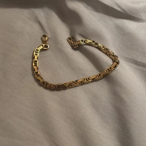 Chunky guldarmband med länkdesign - Snyggt chunky armband i guld med cool länkdesign som ger en lyxig vibe. Armbandet har en klassisk karbinlås och är perfekt för dig som gillar statement-smycken. Passar både till jeans och dressat, och är lätt att matcha med andra accessoarer.