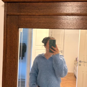 Ljusblå stickad tröja med krage - Supermysig ljusblå stickad tröja med bred krage och ribbad struktur. Tröjan har en loose passform och långa ärmar, perfekt för kyliga dagar. Djur och rökfritt hem. 