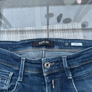 Replay Anbass jeans – W33 L32 - Snygga jeans från Replay, modell Anbass. Klassisk mörkblå tvätt med skön stretch som gör dem bekväma att bära. Modellnummer: M914Y.000.141 00 Tillverkade i Tunisien.  ✅ Storlek: W33 L32 ✅ Passform: Slim fit / rak modell ✅ Färg: Mörkblå ✅ Märke: Replay ✅ I fint begagnat skick – inga hål eller fläckar. Nypris ca 2000kr 