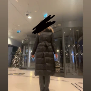Svart lång jacka  - Använd endast några gånger under en vinter. Storlek M. Säljs endast för att jag gått ner i vikt och köpt en mindre storlek i en annan färg. Den levererades tyvärr med ett litet hål i ena fickan (så undvik småsaker där eller sy en enkel söm om du vill), men det har aldrig stört mig i användning. Finns även i liknande modeller hos både Fur Stockholm och Feminina Som på många liknande ( även helt nya ) jackor kan det sticka ut lite av det vita innerma-terialet pa vissa ställen. Fuskpäls✨