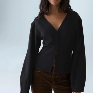 Svart blus med v-ringning och knappar - Snygg svart blus med v-ringad hals och knappar framtill. Köpt för 299kr säljer den för 200kr storlek xs!! Knappt använd💕