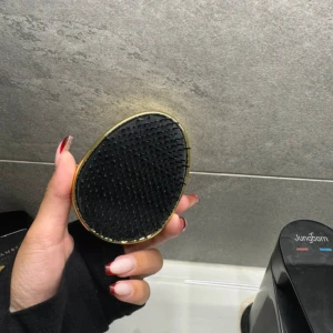 Ecoestic svart och guld brush  - Säljer en snygg detangling brush från Ecoestic i svart och guld. Borsten har en oval form med mjuka svarta strån och ett guldigt plasthölje.
