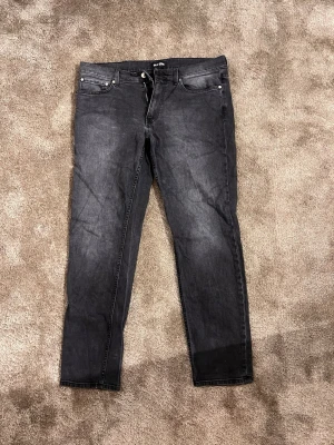 Svarta jeans från BLK DNM - Säljer ett par svarta jeans från BLK DNM med klassisk femficksdesign och dragkedja i gylfen. Jeansen har en rak passform och är tillverkade i slitstarkt denimtyg. Perfekt för dig som gillar en stilren look med mörka toner.