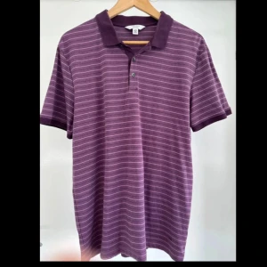 Randig lila pikétröja från Calvin Klein - • Kortärmad randig lila Pikétröja från Calvin Klein i L. • 100% bomull. • Tvättad men oanvänd.