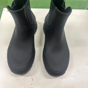 Svarta Tretorn chelsea boots - Säljer ett par svarta chelsea boots från Tretorn med grov mönstrad sula och elastiska paneler på sidorna. Skorna är tillverkade i slitstark syntet och har en rund tå samt platt sula. Perfekta för regniga dagar och outdoor.