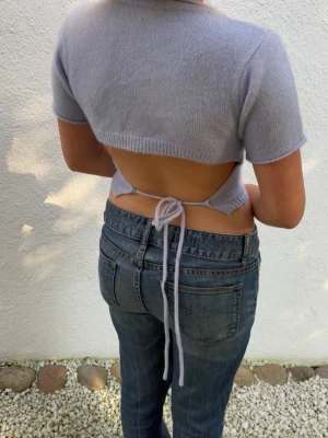 Stickad topp - Superfin ljuslila croppad stickad topp med korta ärmar och öppen rygg som knyts med snören baktill. Mjuk och skön känsla, perfekt för varmare dagar. Skit snygg till fest!🙌💜