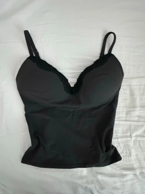 SKIMS push up cami - Fits everybody lace push up cami från SKIMS!  En silkeslen topp med en smickrande urringning och en inbyggd push-up BH utan bygel som ger ett fint lyft och sitter bekvämt. Den har också justerbara band.   Helt ny, aldrig använd! Endast testad. Den är helt slutsåld på hemsidan. Köpt för 876 kr + 110 kr i frakt