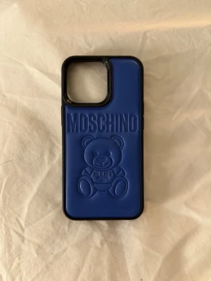 Moschino skal  - Säljer mitt blåa mobilskal från Moschino som är oanvänt! Passar 13 PRO, 14 PRO och 15 PRO💕