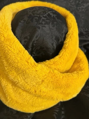 Gul fluffig pälsväst - Säljer en supermjuk och fluffig gul pälsväst i fuskpäls. Västen har en enkel och stilren design utan knappar eller dragkedja, perfekt att slänga över en hoodie eller tröja för extra värme. Färgen är riktigt poppig och ger en cool statement-look.