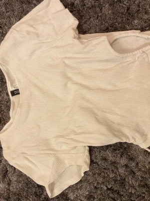 Vit topp från H&M  - Magtröja med knutar i midjan