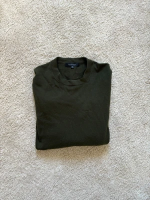 Grön stickad ulltröja - Säljer denna snygga mörkgröna ulltröjan från Paul & friends. 100% merinoull. Fint skick! Köpt på NK i Stockholm för ca 1800kr. Storlek M. 