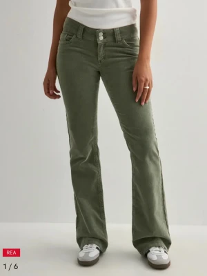 Gröna bootcut manchesterbyxor - Snygga gröna manchesterbyxor med bootcut-snitt och hög midja. Byxorna har klassiska fickor fram och bak, samt två knappar i midjan. Materialet är mjukt och har tydlig struktur, perfekt för dig som gillar retrovibbar och vill sticka ut. Dem är i storlek M men passar även en person med storlek S