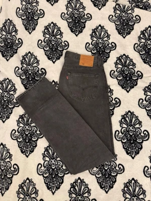 Levi’s 501 Original Jeans – Vintage Mörkgrå Denim - Autentiska Levi’s 501 Original Fit jeans i mörkgrå/tvättad svart denim.  En riktig vintageklassiker med tidlös rak passform. Perfekt för vardagsbruk och lätt att styla året runt.  Storlek 33/36 Midja: 43 cm Innersida benlängd: 89 cm Yttersida benlängd: 117 cm  Perfekt för vintage, Y2K, streetwear och minimalistiska outfits.  Bra vintageskick med normalt slitage som ger karaktär. Inga större defekter (se bilder).  Jag har vikt dem vid användning (se sista bilden)  Tveka inte att höra av dig! 