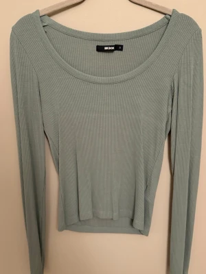 Ljusgrön ribbad topp från Bik Bok - Bik Bok i storlek S. Perfekt att styla med jeans eller kjol för en chill look.