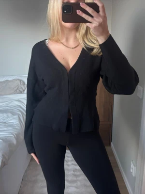 Svart stickad kofta med v-ringning - Säljer en svart stickad kofta med djup v-ringning och långärmade, lite loose ärmar. 😍