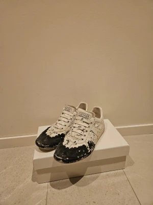 Maison margiela gats - Maison margiela gats vit sko med blå stänk. Storlek 43 skicka 8,5/10 enligt mig. Dessa skor är nästintill omöjliga att få tag i då de inte säljs längre. Box och dustbags medföljer som på bilder. Hör av er för vidare frågor!