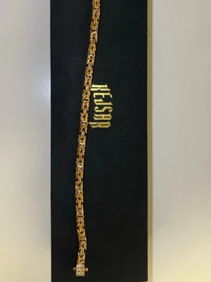 Armband kejsar - Bilden visar ingen väst, utan ett smycke (armband eller halsband) i guld och silverfärg från Kejsar.