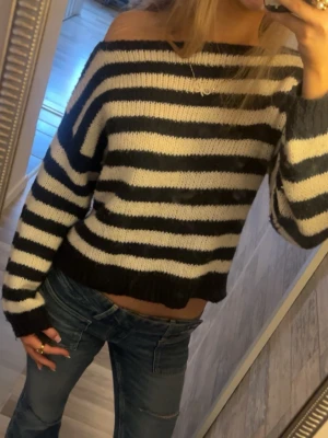 Randig stickad tröja Gina Tricot - Säljer en stickad tröja från Gina Tricot i storlek 146/152. Tröjan är randig i marin blå och vitt, har offshoulder-design och är croppad med långa ärmar💞