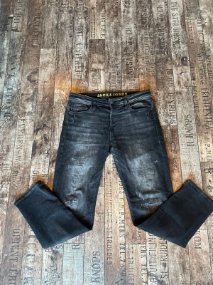 Jeans från Jack & Jones  - Säljer ett par svarta jeans från Jack & Jones med lite slitningar. Modellen heter Comfort Mike. | Skriv vid funderingar |