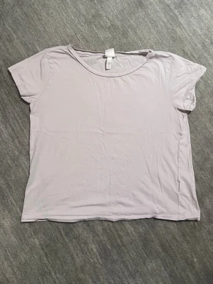 Grå bomulls T-Shirt  - Säljer denna tunna och sköna bomulls T-Shirten som passar perfekt till en sommardag eller att sova i. T-shirten är sparsamt använd (kanske 2-3 gånger). Inga defekter eller tecken på användning.