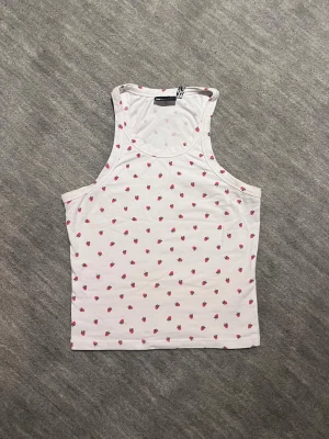 Jätte sött linne - Säljer mitt ursöta vita linne med jordgubbar på då det tyvärr blivit för litet. Passar perfekt att ha på sommaren eller under en kofta när det är lite kallare. Linnet är sparsamt använt och inga tecken på användning finns. 