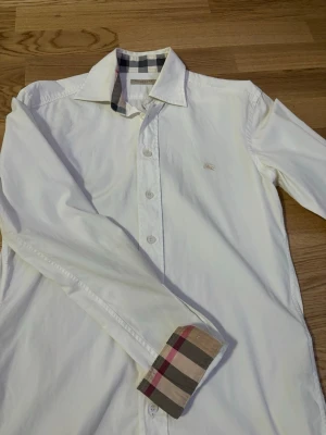 Vit Burberry skjorta  - Snygg vit skjorta från Burberry äkta såklart och har haft den i 1 år använde några få gånger och vill sälja derför det har inte kommit till användning längre
